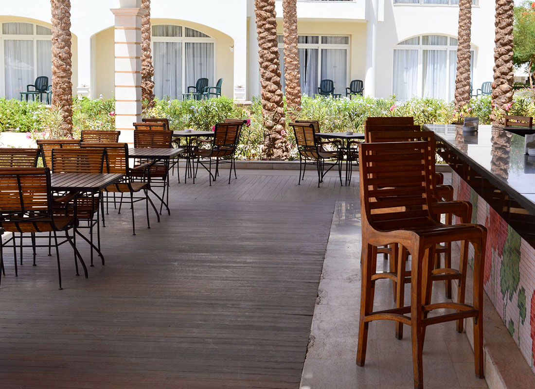 Insurance by Industry - View of Wooden Outdoor Seating in a Cafe in Florida Surrounded by Palm Trees