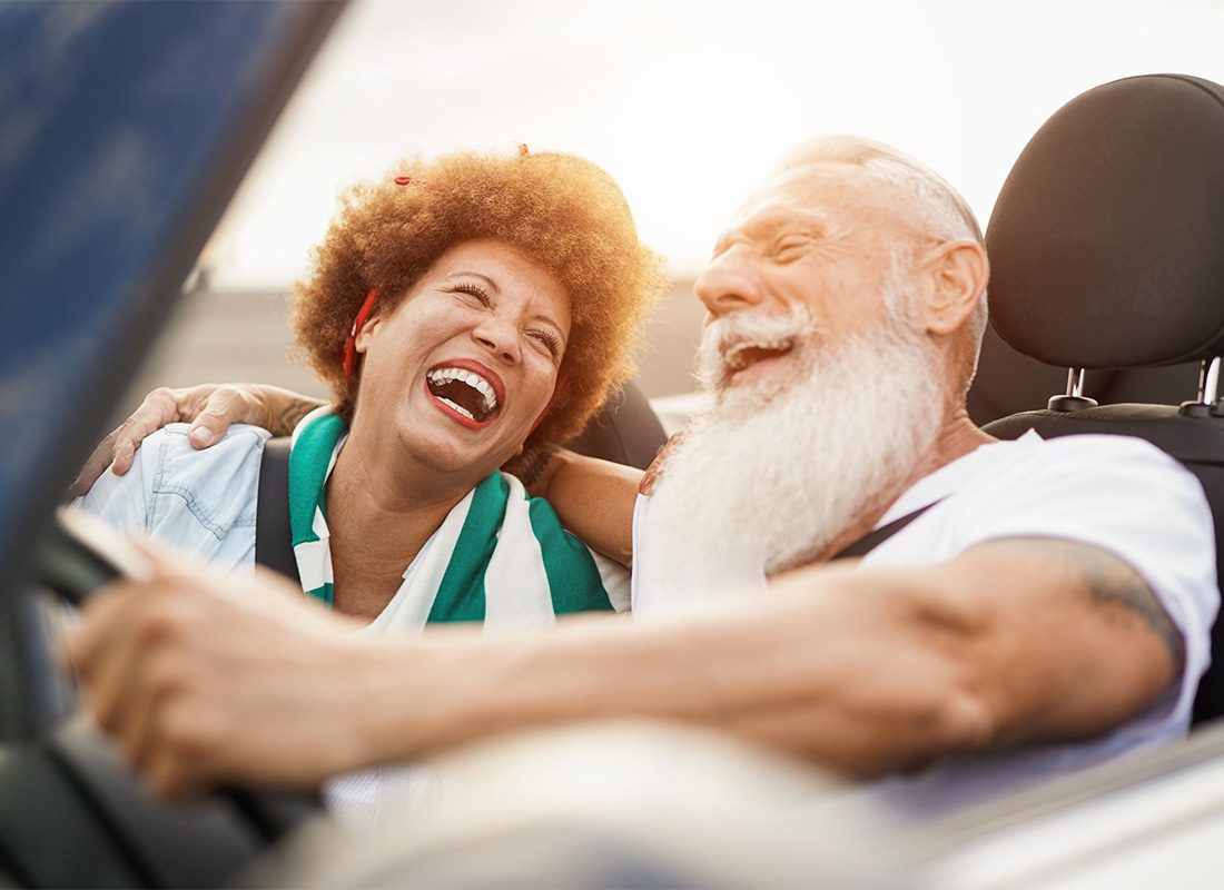 Service Center - Closeup Portrait of a Cheerful Elderly Couple Driving in a Convertible Car Along the Beach During a Summer Road Trip